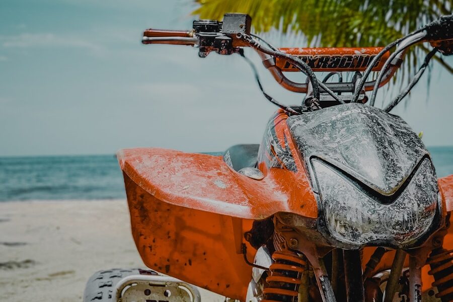 orange and black motorcycle on beach during daytime